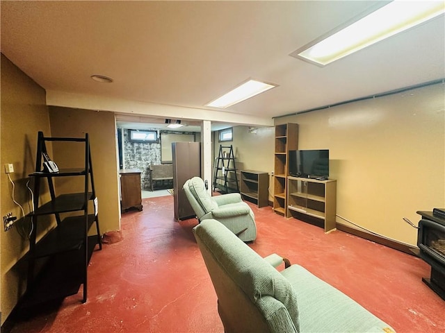 living area with a wood stove and concrete floors