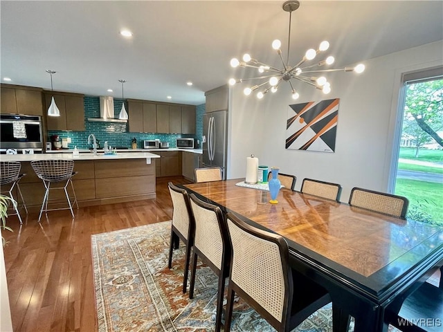 dining room featuring light wood finished floors, recessed lighting, and a notable chandelier