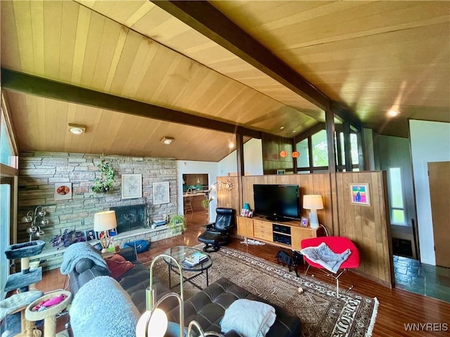 living room with wood finished floors, lofted ceiling with beams, a wealth of natural light, a stone fireplace, and wooden ceiling