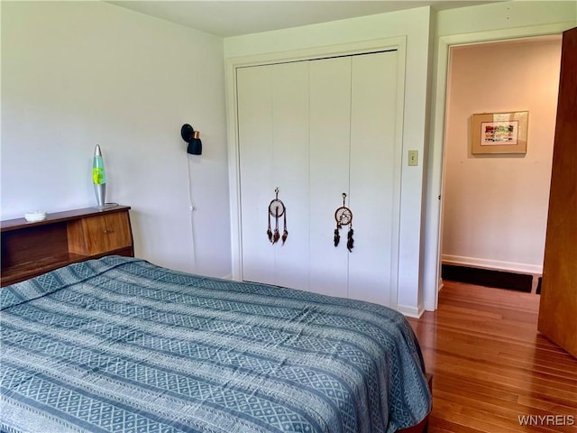 bedroom featuring a closet, baseboards, and wood finished floors