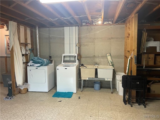 laundry area with tile patterned floors, washing machine and dryer, a sink, and laundry area