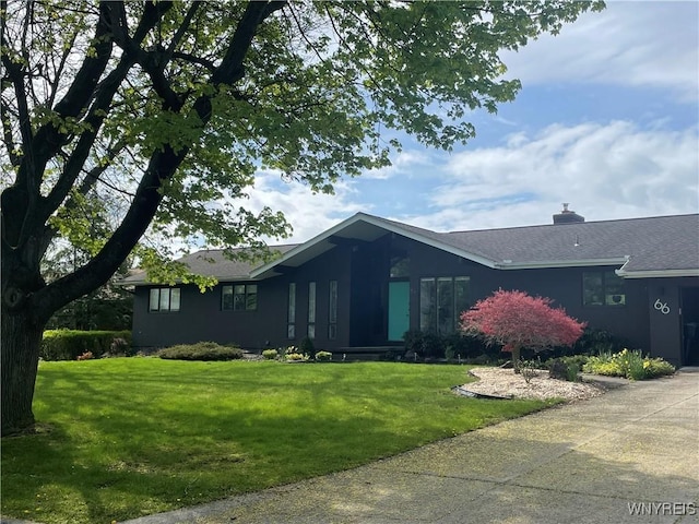 view of front facade featuring roof with shingles and a front lawn
