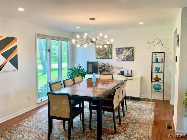 dining space featuring an inviting chandelier, visible vents, dark wood-style flooring, and baseboards