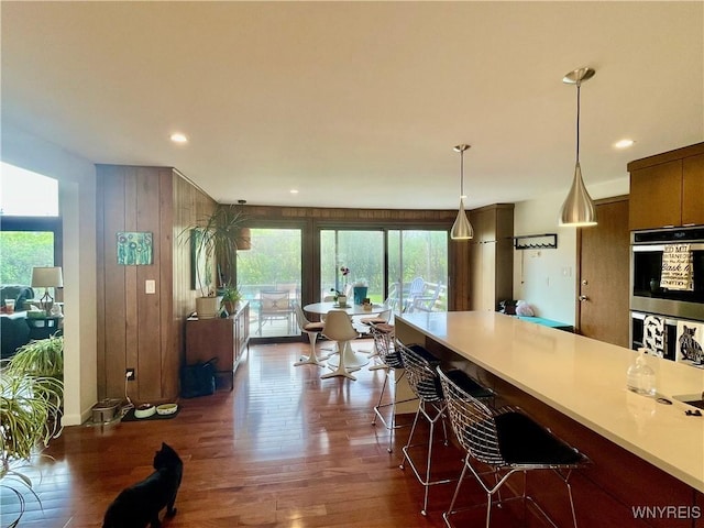kitchen with light countertops, plenty of natural light, dark wood-type flooring, and stainless steel double oven