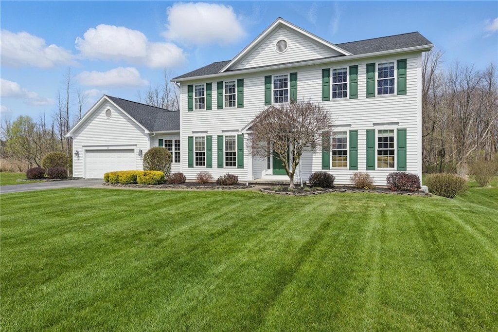 view of front of property featuring aphalt driveway, a front lawn, and a garage