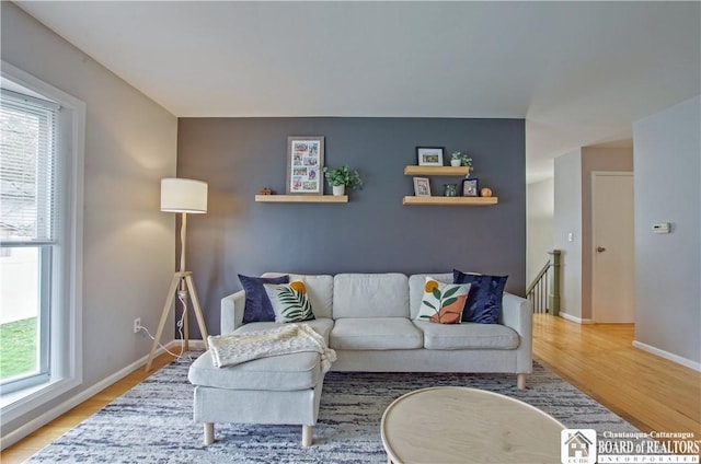 living area featuring baseboards and light wood-style floors