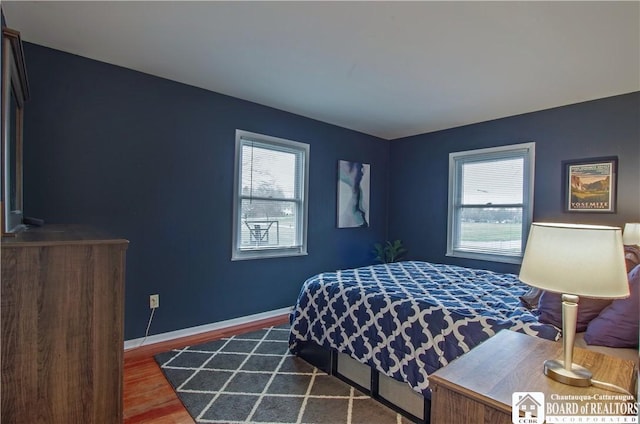 bedroom featuring baseboards and wood finished floors