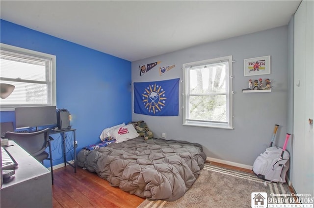 bedroom with wood finished floors and baseboards