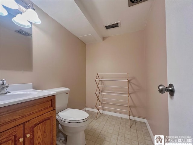 half bath featuring baseboards, toilet, vanity, and visible vents