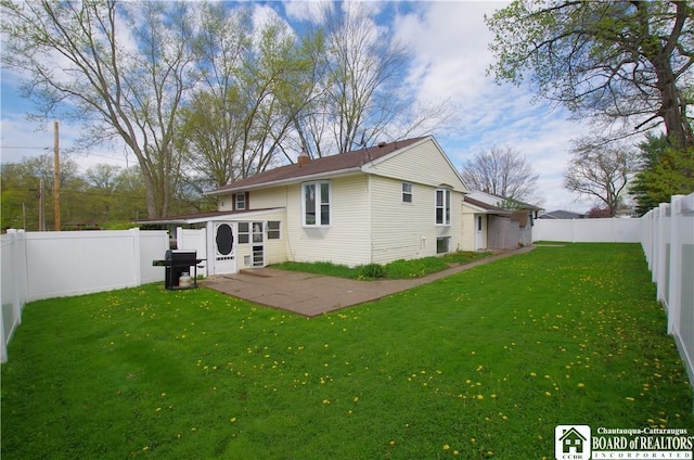 back of house featuring a lawn, a patio, and a fenced backyard