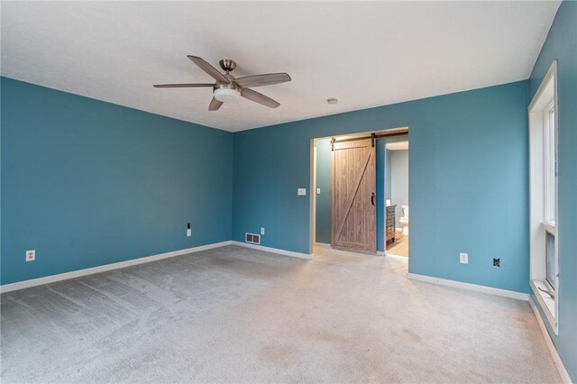 7893 Lake Rd, Sodus, NY 14555 - unfurnished bedroom with light colored carpet, a barn door, baseboards, and visible vents