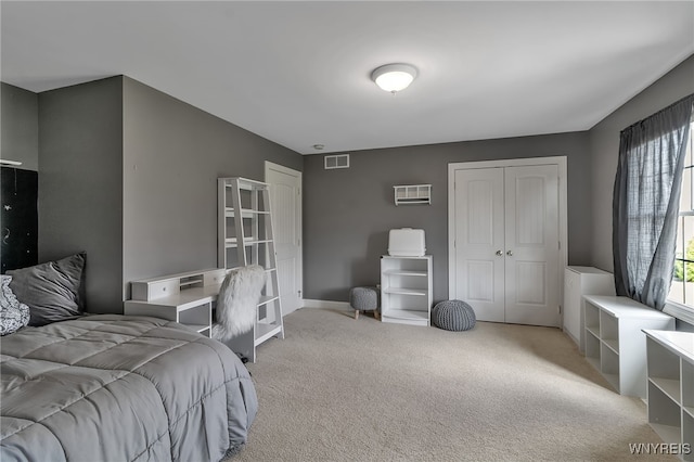carpeted bedroom with a closet, baseboards, and visible vents