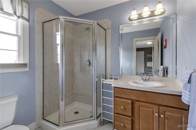 bathroom featuring a stall shower, vanity, toilet, and tile patterned flooring
