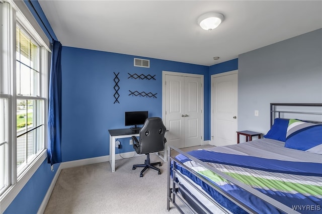 bedroom with carpet flooring, baseboards, visible vents, and multiple windows