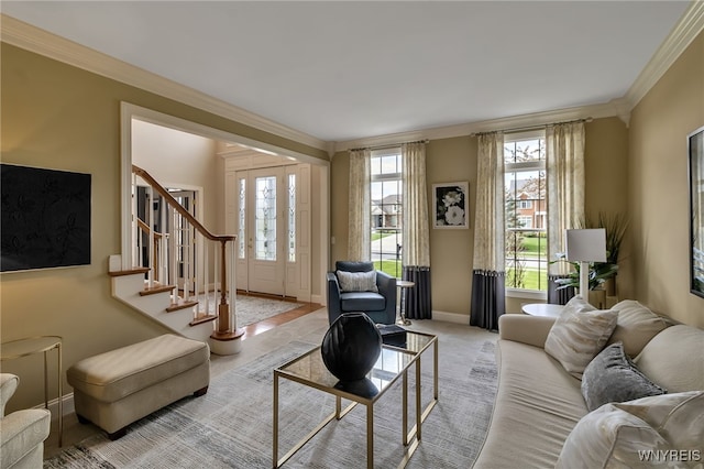 living area with baseboards, stairway, crown molding, and plenty of natural light