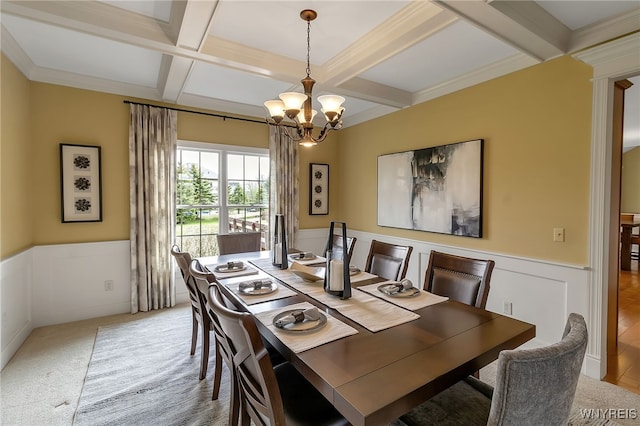 dining area with a notable chandelier, a wainscoted wall, beam ceiling, and coffered ceiling