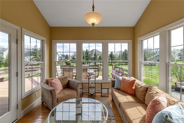 sunroom featuring baseboards and lofted ceiling