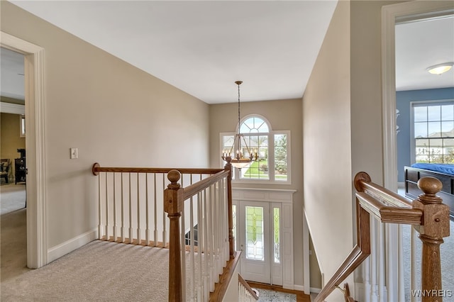 interior space featuring carpet flooring, baseboards, and a notable chandelier