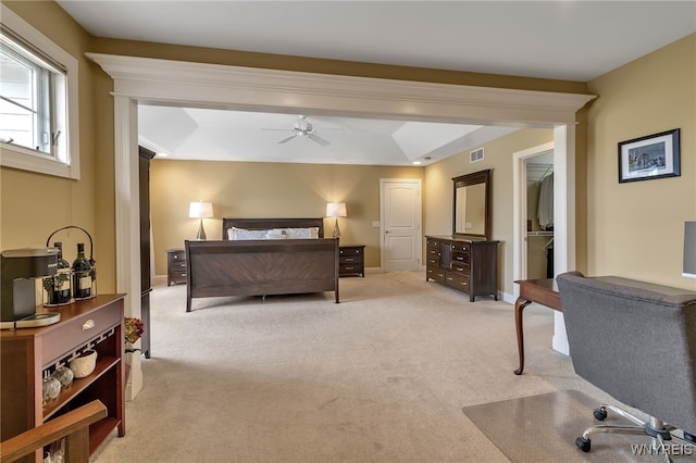 bedroom with visible vents, baseboards, ceiling fan, light carpet, and a spacious closet