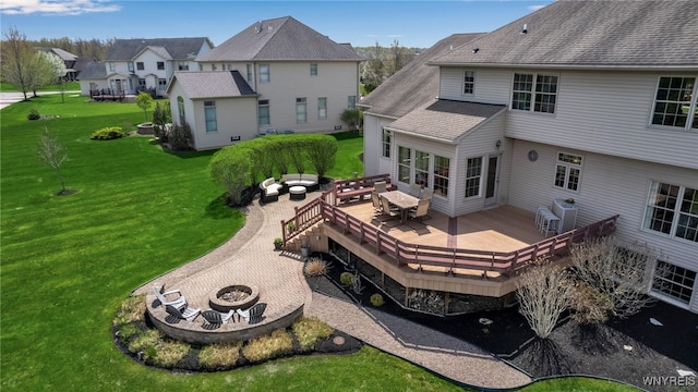 rear view of property with a yard, a residential view, a wooden deck, an outdoor living space with a fire pit, and roof with shingles