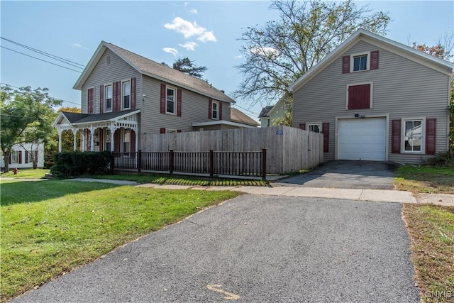view of front of property featuring aphalt driveway, fence, and a front yard