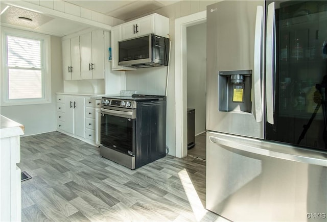 kitchen with light countertops, white cabinetry, and stainless steel appliances