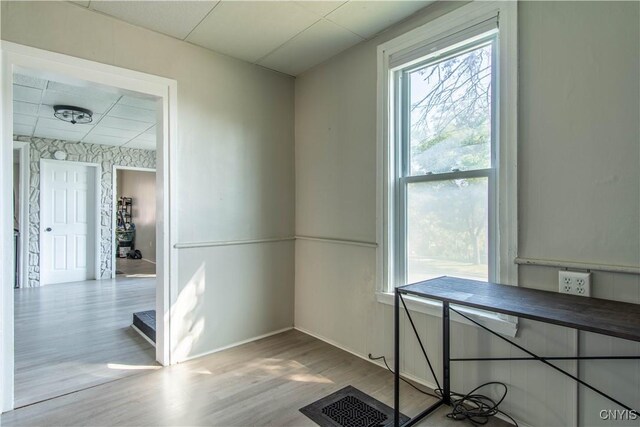 unfurnished office with plenty of natural light, wood finished floors, and baseboards