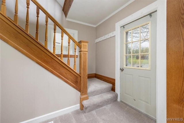 entryway with stairway, ornamental molding, carpet flooring, and baseboards