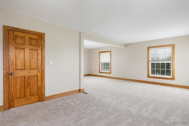 empty room featuring baseboards and carpet flooring