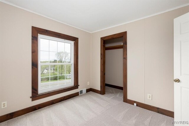 unfurnished bedroom featuring crown molding, visible vents, and baseboards