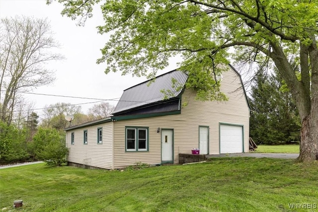 view of front of home featuring metal roof, driveway, and a front yard
