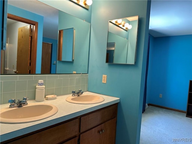 full bath with a sink, double vanity, tasteful backsplash, and baseboards