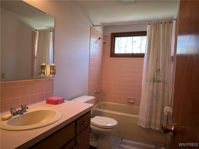 full bath with vanity, shower / tub combo with curtain, toilet, and visible vents