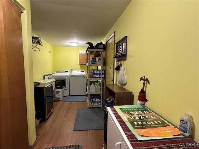 laundry room with cabinet space, independent washer and dryer, and wood finished floors