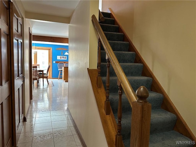 stairway with baseboards and tile patterned flooring