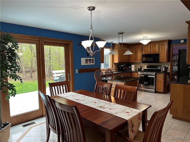 dining area with light tile patterned floors, visible vents, and a healthy amount of sunlight