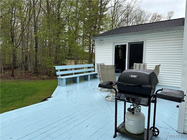 wooden terrace with grilling area and a lawn