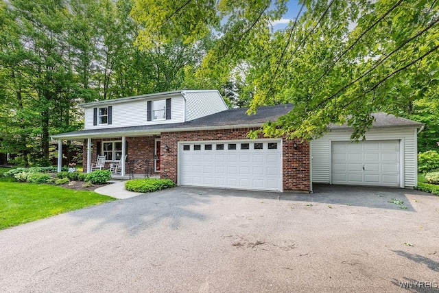 103 Old Orchard Ln, Orchard Park, NY 14127 - traditional-style home with a porch, driveway, brick siding, an attached garage, and a front yard
