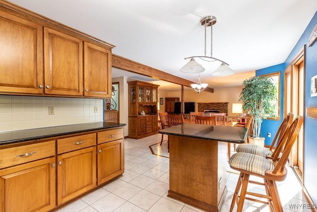 103 Old Orchard Ln, Orchard Park, NY 14127 - kitchen with a kitchen breakfast bar, dark countertops, brown cabinetry, backsplash, and beamed ceiling
