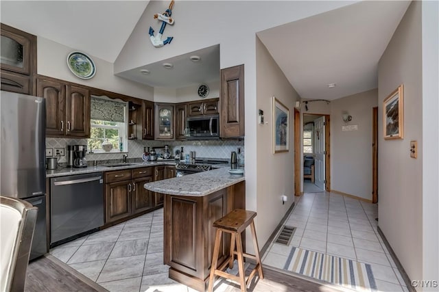 44458 County Route 100, Alexandria, NY 13640 - kitchen featuring visible vents, dark brown cabinetry, a peninsula, decorative backsplash, and appliances with stainless steel finishes