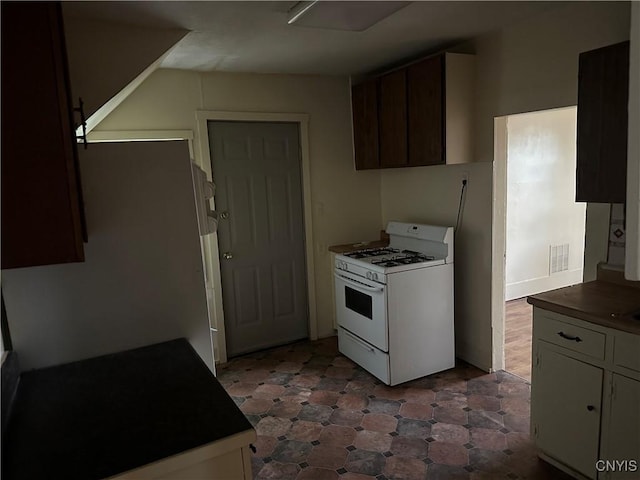 113 Grumbach Ave, Syracuse, NY 13203 - kitchen featuring dark floors, visible vents, white gas stove, and dark countertops