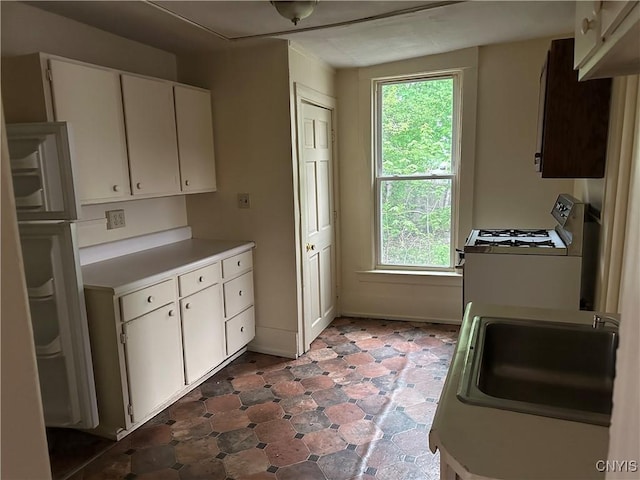 113 Grumbach Ave, Syracuse, NY 13203 - kitchen featuring a sink, white cabinets, tile patterned floors, light countertops, and gas range gas stove