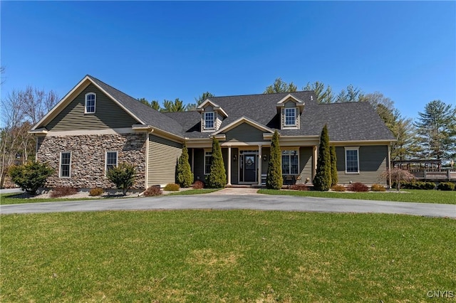 view of front facade featuring a front lawn, stone siding, and aphalt driveway
