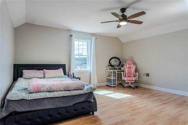 bedroom with lofted ceiling, baseboards, visible vents, and wood finished floors