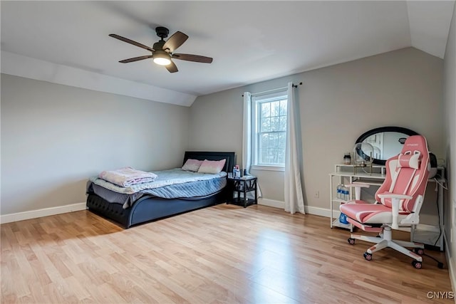 bedroom featuring lofted ceiling, baseboards, a ceiling fan, and wood finished floors