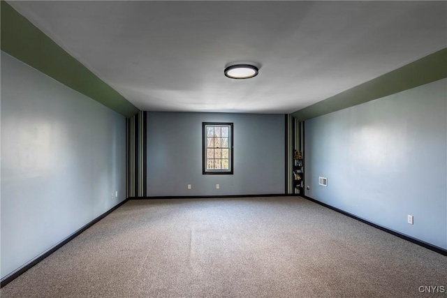 unfurnished room with baseboards and carpet floors