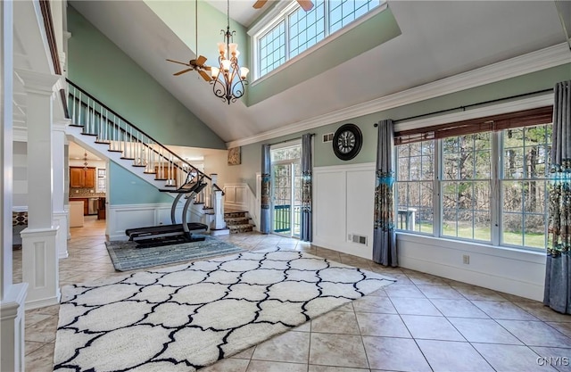 entrance foyer with stairway, tile patterned floors, a decorative wall, and crown molding