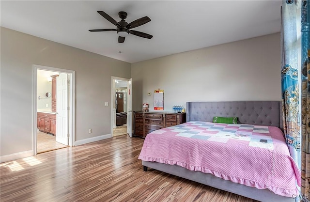 bedroom featuring ensuite bath, ceiling fan, baseboards, and wood finished floors