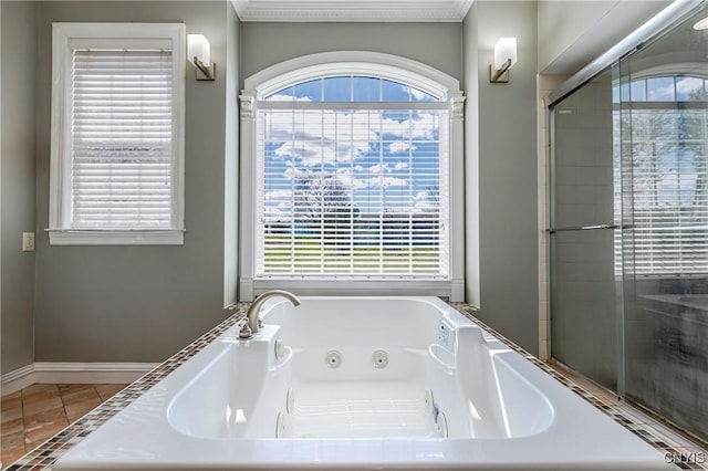 bathroom with tile patterned flooring, a whirlpool tub, and a healthy amount of sunlight