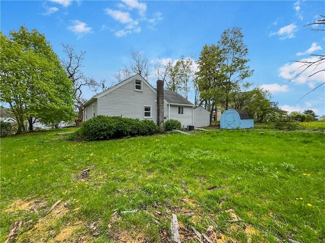 131 W Sullivanville Rd, Veteran, NY 14845 - view of side of property with a storage shed, a chimney, an outdoor structure, and a yard